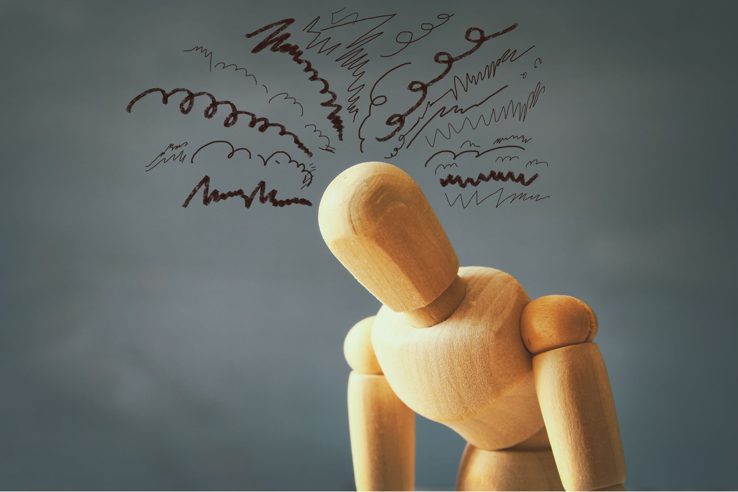 Wooden figure with chaotic scribbles above its head symbolizing overthinking and common mistakes in beginner meditation practice.