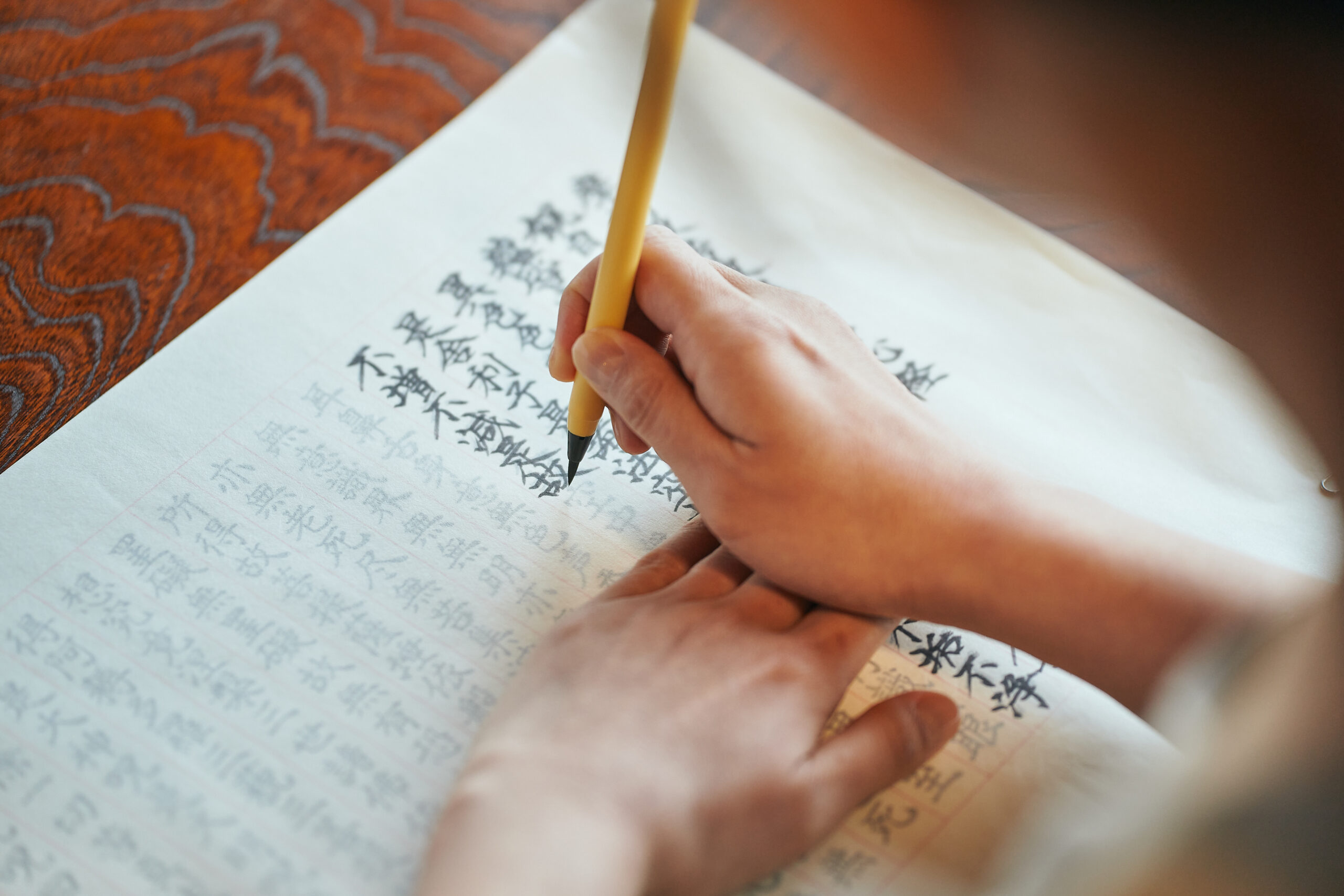 Hands tracing sutra and soft focus meditation scenes symbolizing participants' calm experiences at Zen retreat