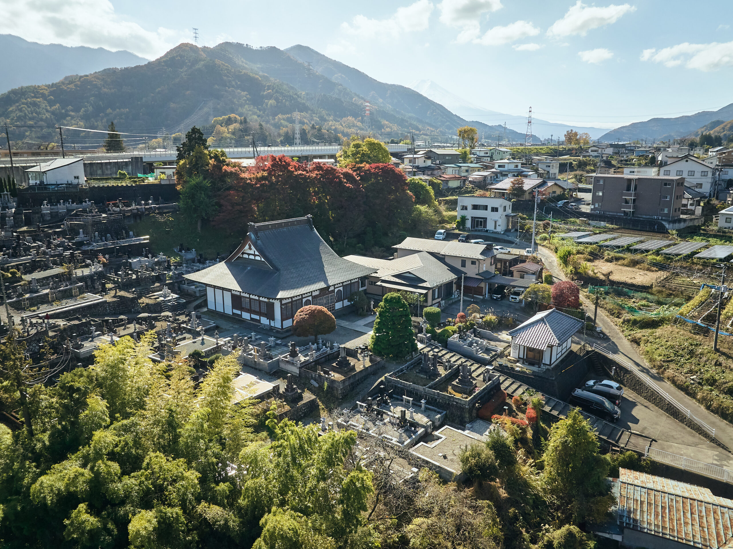 富士山麓の山梨県都留市にある禅寺・耕雲院を上空から撮影した風景。寺と紅葉、周囲の里山の景色が一望できる。