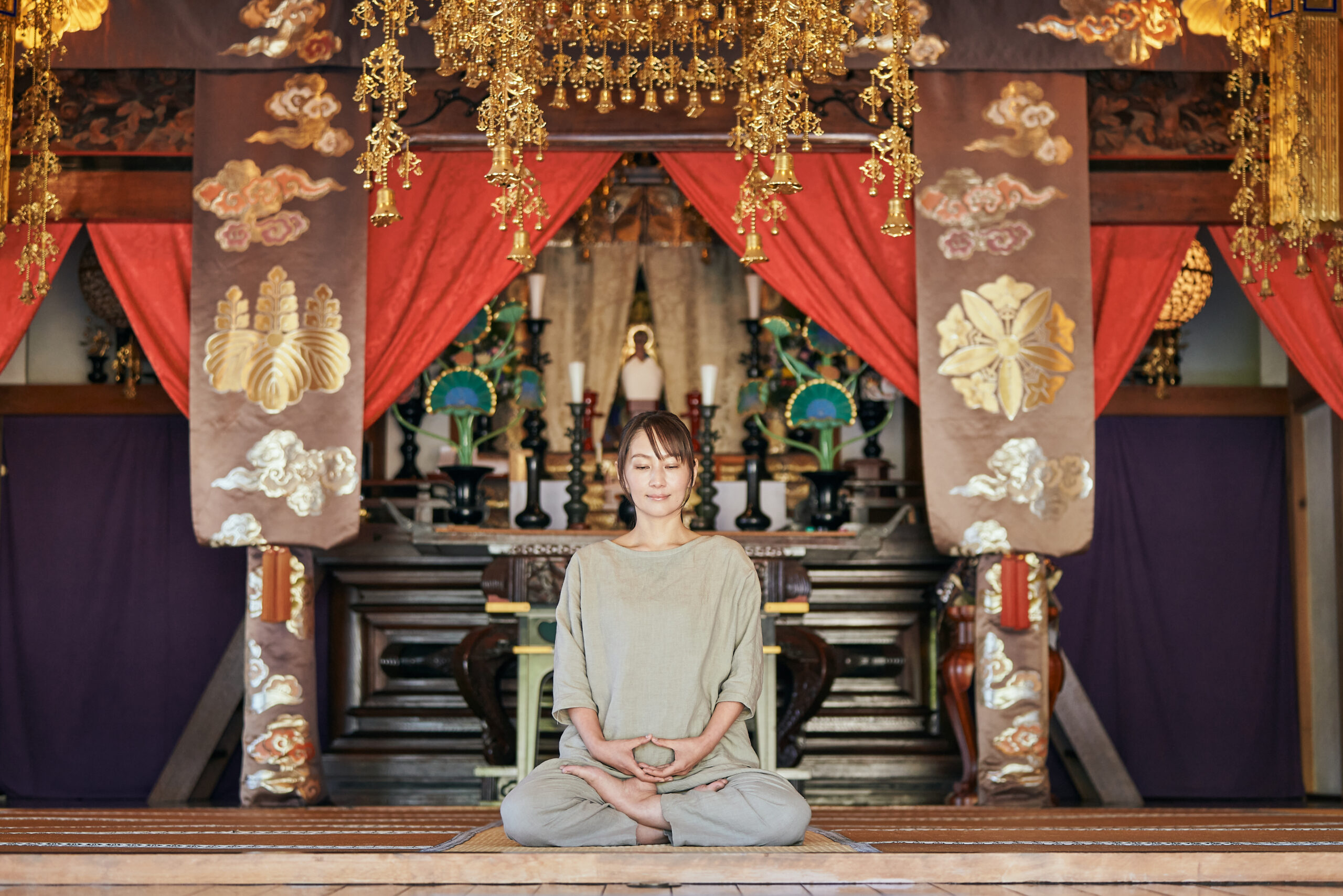 木造の本堂で坐禅を体験する人。自然光が差し込む静かな空間