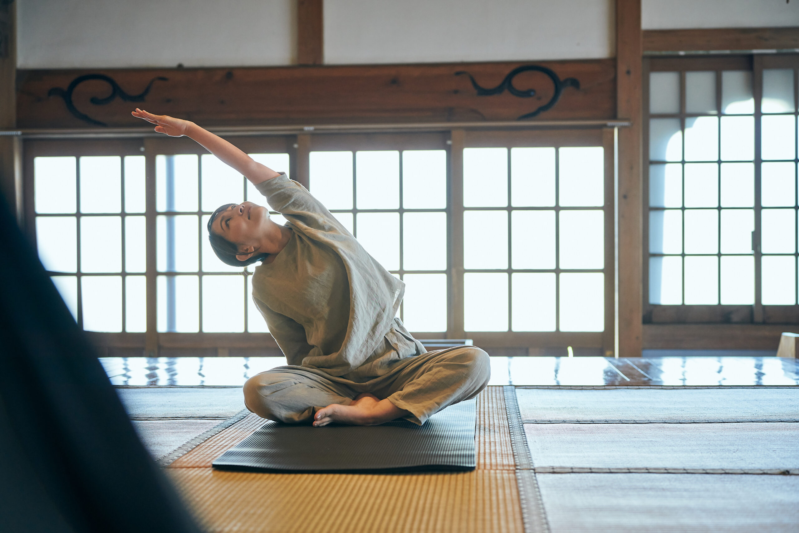 畳の上でゆっくりと身体をほぐすヨガの時間。坐禅前の準備として呼吸を整える。